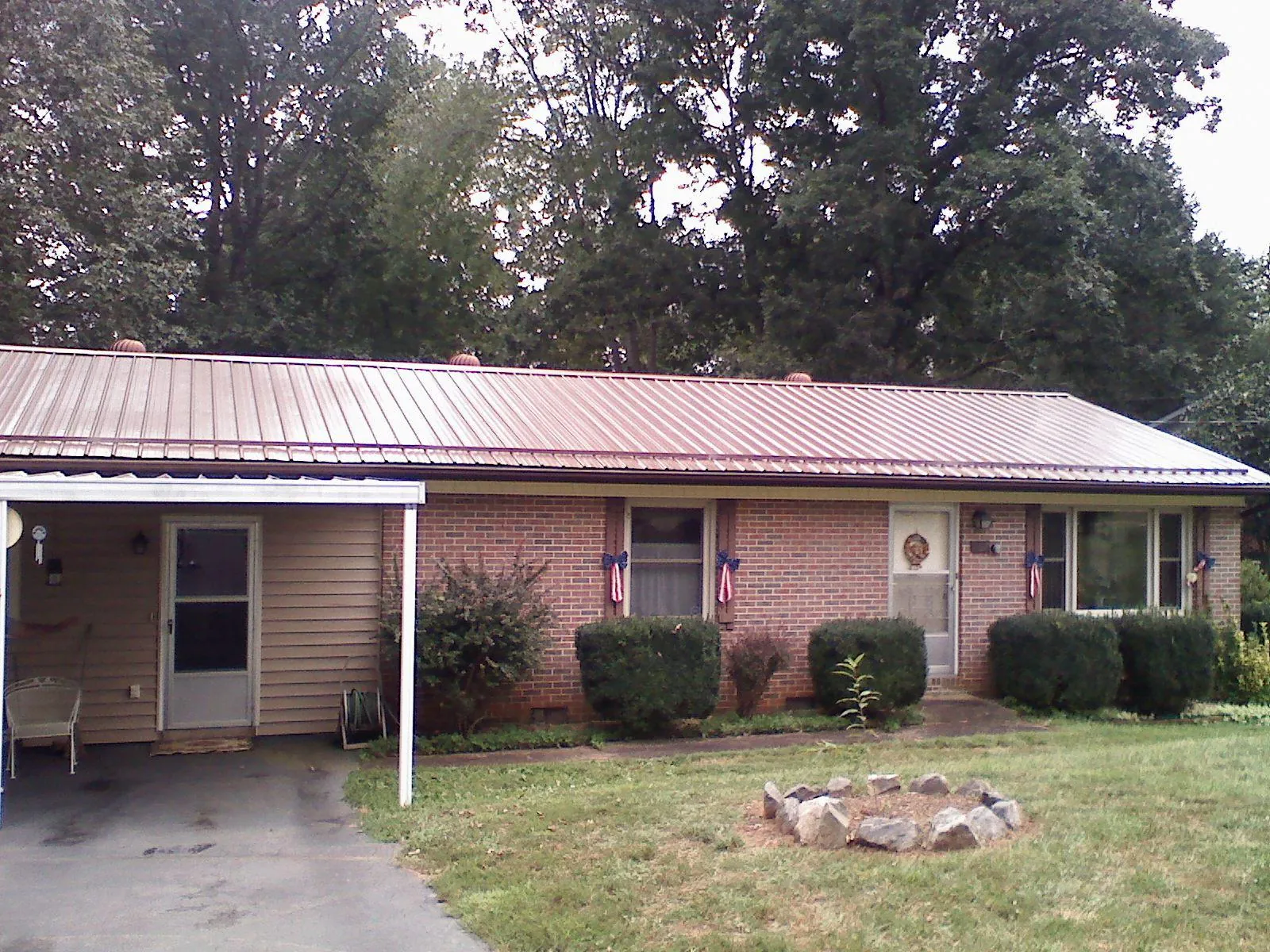 Bronze metal roof and carport on a brick ranch home — Roof Repair work by our crew in Sultan